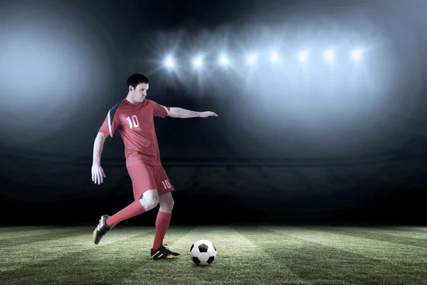 Jugador de fútbol en rojo patadas — Foto de Stock