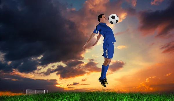 Jugador de fútbol en salto azul —  Fotos de Stock