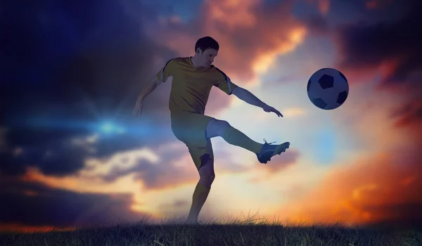 Football player in yellow kicking — Stock Photo, Image