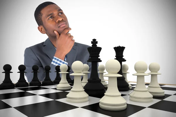 Бизнесмен думает с шахматной доской — стоковое фото