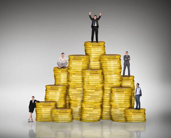 Business people on pile of coins — Stock Photo, Image