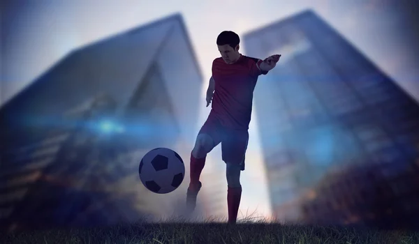 Giocatore di calcio in rosso calci — Foto Stock