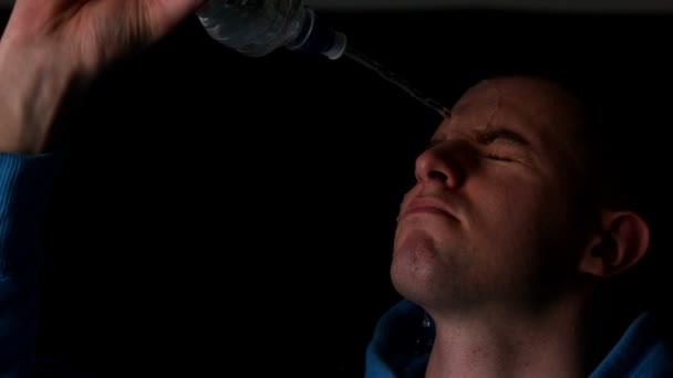 Чоловік наливає воду на обличчя — стокове відео