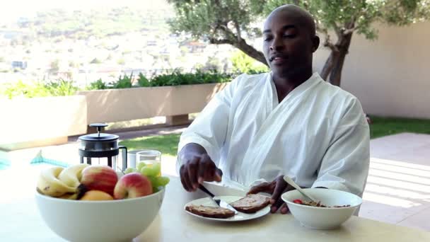 Man eating breakfast outdoors — Stock Video