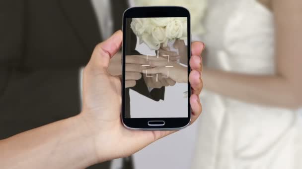 Main montrant des clips de mariage sur smartphone — Video