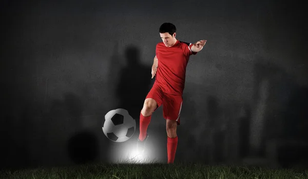 Fotballspiller i rødt spark – stockfoto