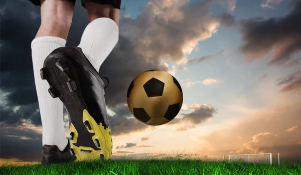 Football boot kicking gold ball — Stock Photo, Image
