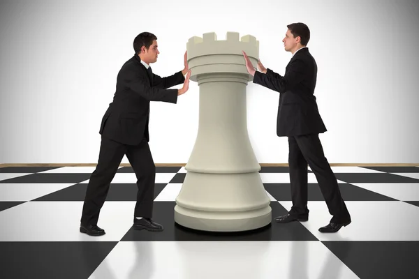 Business people pushing chess piece — Stock Photo, Image