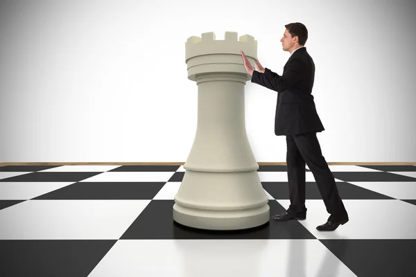 Businessman in suit pushing chess piece — Stock Photo, Image