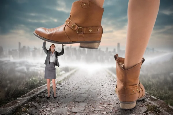 Cowboy boots stepping on businesswoman — Stock Photo, Image