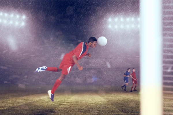 Giocatore di calcio saltare contro lo stadio di calcio — Foto Stock