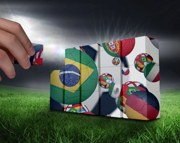 Hand building wall against football — Stock Photo, Image