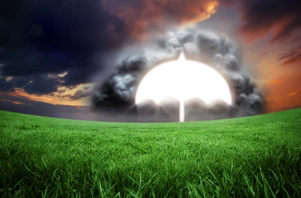 Umbrella in cloud against green field — Stock Photo, Image