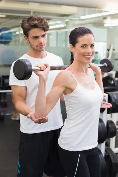 Mulher levantando barbell com seu treinador — Fotografia de Stock