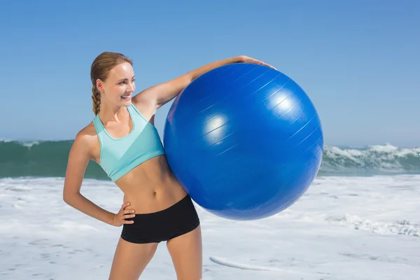 Mujer en playa sosteniendo pelota de ejercicio — Foto de Stock