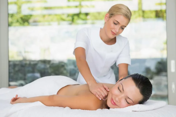 Brünette bekommen ein rückenmassage — Stockfoto