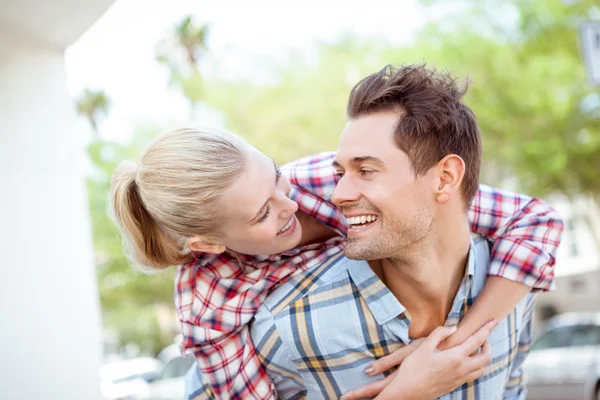 Man die zijn vriendin geeft een piggy back — Stockfoto