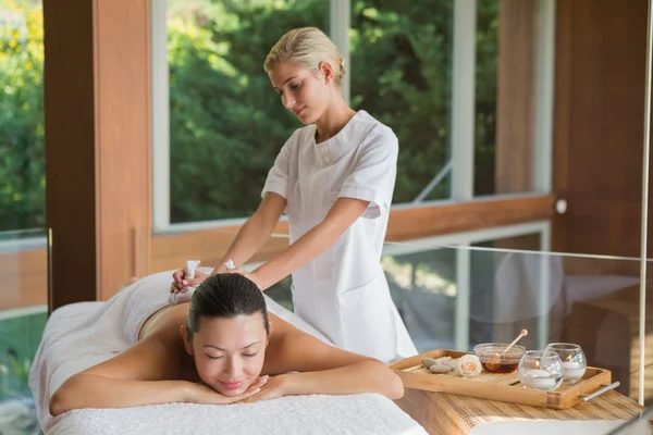 Brünette genießt eine Kräuterkompresse Massage — Stockfoto