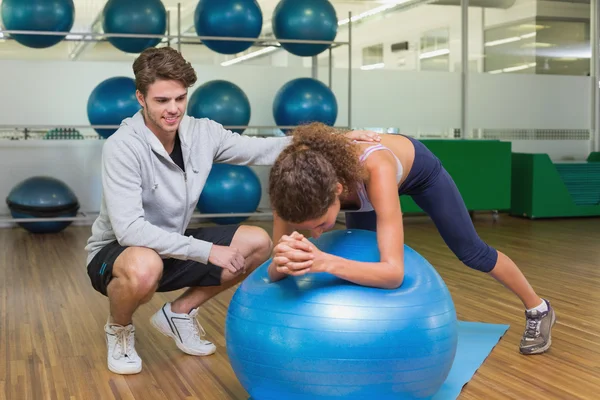 Treinador assistindo seu cliente usando bola de exercício — Fotografia de Stock