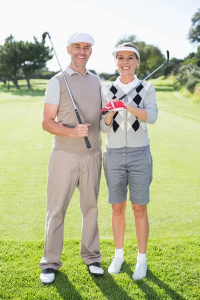 Golf pareja celebración clubs — Foto de Stock