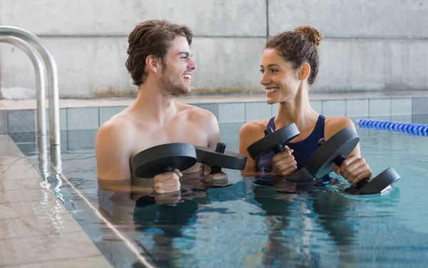 Homme et femme avec haltères dans la piscine — Photo