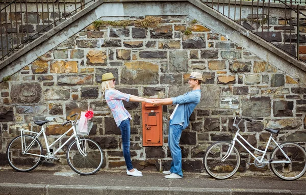 Hip couple dancing by wall with bikes — Stock Photo, Image