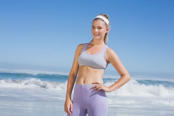 Sportig leende blondin på stranden — Stockfoto