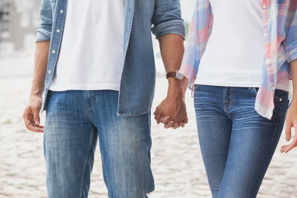 Hüftiges junges Paar hält Händchen — Stockfoto