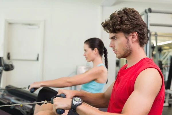 Man working out on the rowing machine — Stock Photo, Image