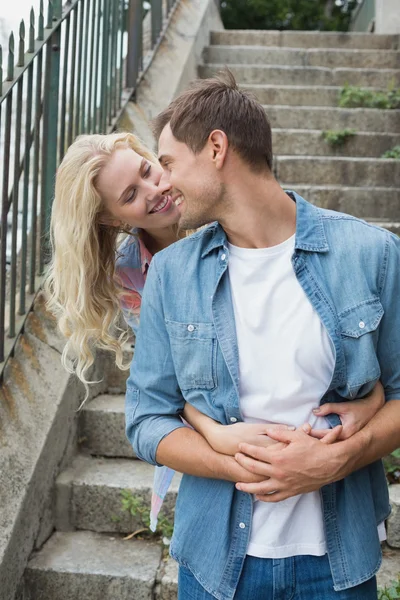 Hip couple standing by steps hugging — Stock Photo, Image