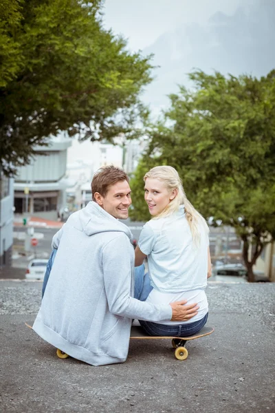 Hoftepar som sitter på rullebrett – stockfoto