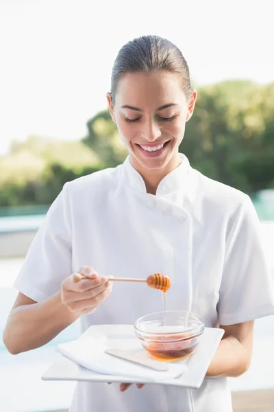 Belleza terapeuta celebración plato con miel — Foto de Stock