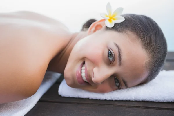 Peaceful brunette lying on towel smiling — Stock Photo, Image