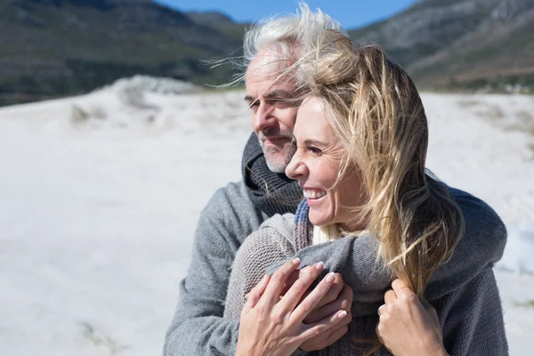 Paar umarmt sich am Strand in warmer Kleidung — Stockfoto