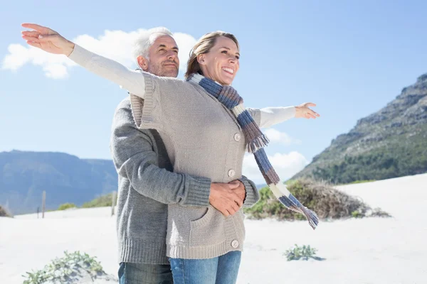 Couple hugging on the beach in warm clothing — Stock Photo, Image