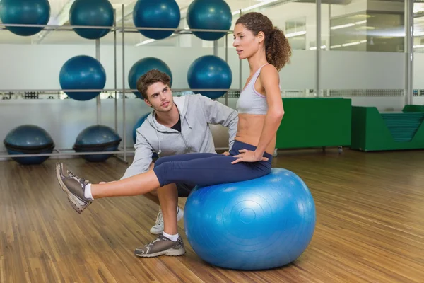 Trainer guardando il suo cliente utilizzando palla esercizio — Foto Stock