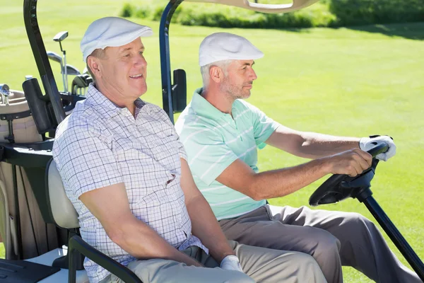 Golfing friends driving in golf buggy — Stock Photo, Image