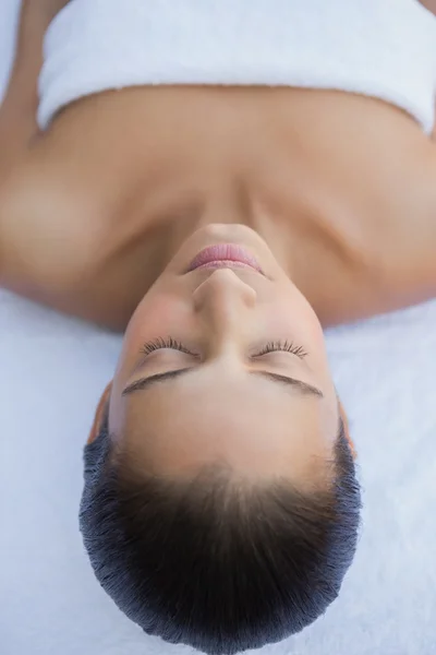 Brunette liggen met de ogen gesloten op een handdoek — Stockfoto