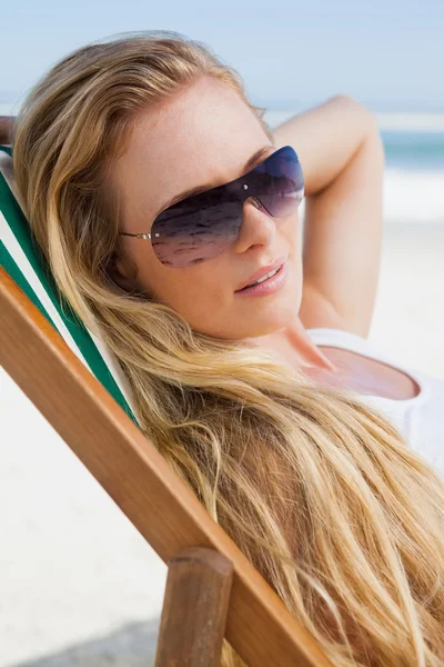 Блондинка в солнечных очках на пляже — стоковое фото