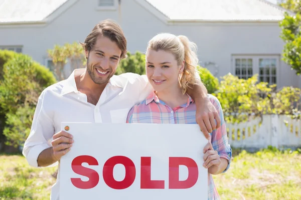 Couple holding sold sign — Stock Photo, Image