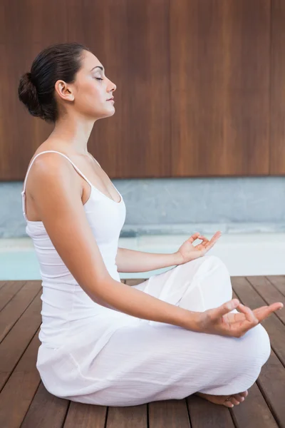 Brunetka v bílém sedí v lotus pose — Stock fotografie