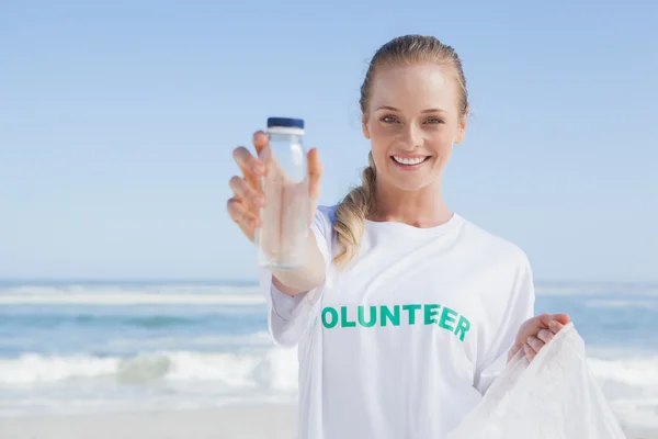 Волонтёр собирает мусор на пляже — стоковое фото