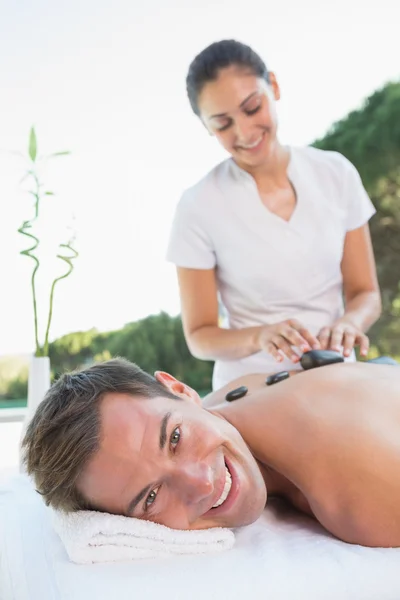 Homem recebendo uma massagem de pedra quente — Fotografia de Stock