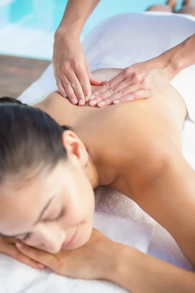 Brunette enjoying a massage poolside — Stock Photo, Image