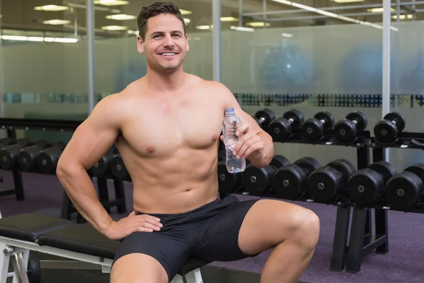 Bodybuilder op Bank met water fles — Stockfoto