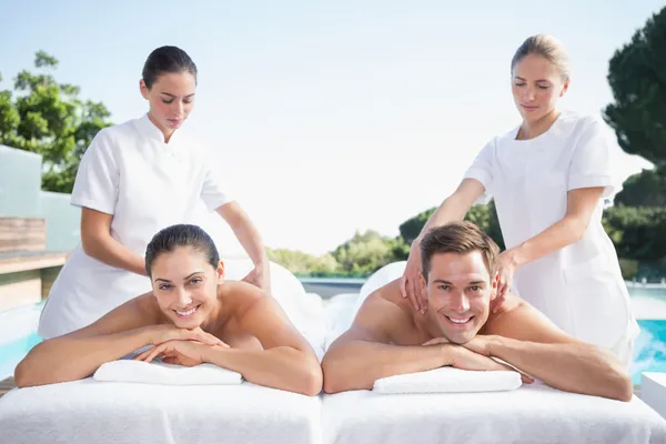 Couple enjoying couples massage poolside — Stock Photo, Image