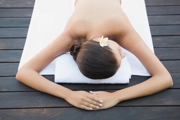 Calma morena acostada en una toalla junto a la piscina — Foto de Stock