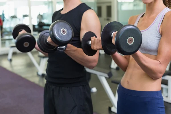 Fit couple lifting dumbbells together — Stock Photo, Image
