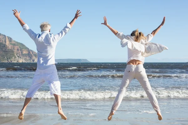 Paar springen op het strand — Stockfoto