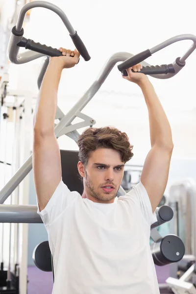 Man using weights machine for arms — Stock Photo, Image